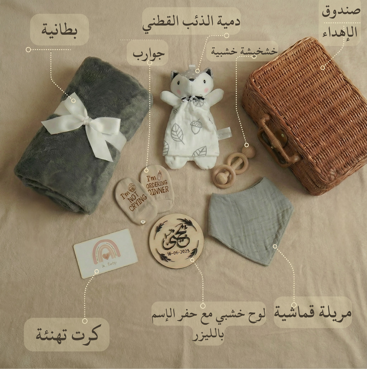 Collection of baby items including a teddy bear, blanket, and wooden toy on a beige background with Arabic text labels.